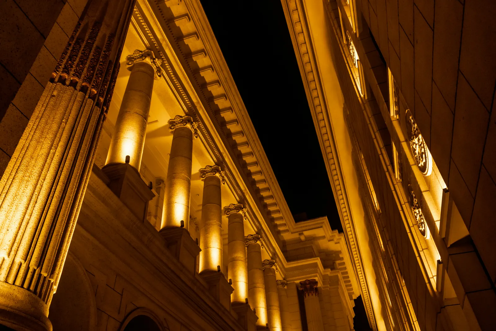 Stone columns uplit with warm narrow-beam lights at night