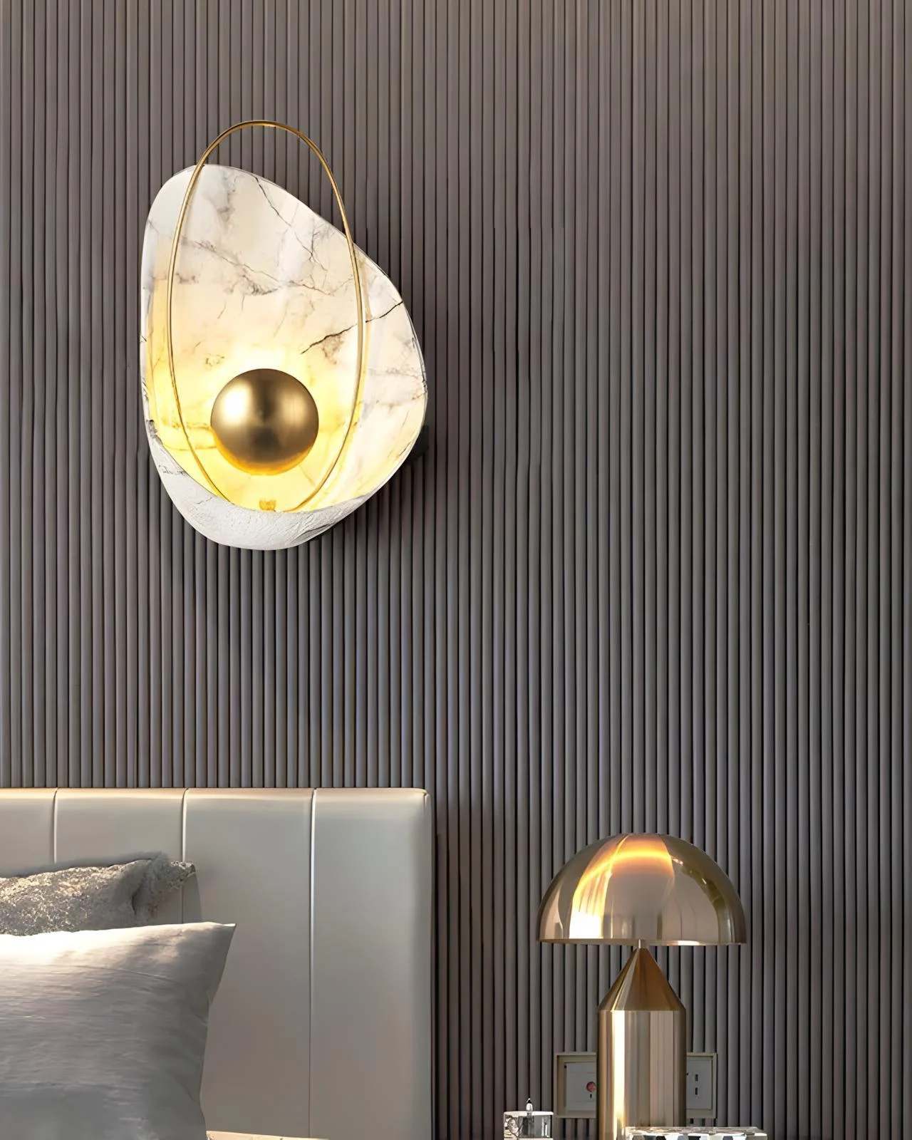 The Dawn marble and brass wall light beside a bed