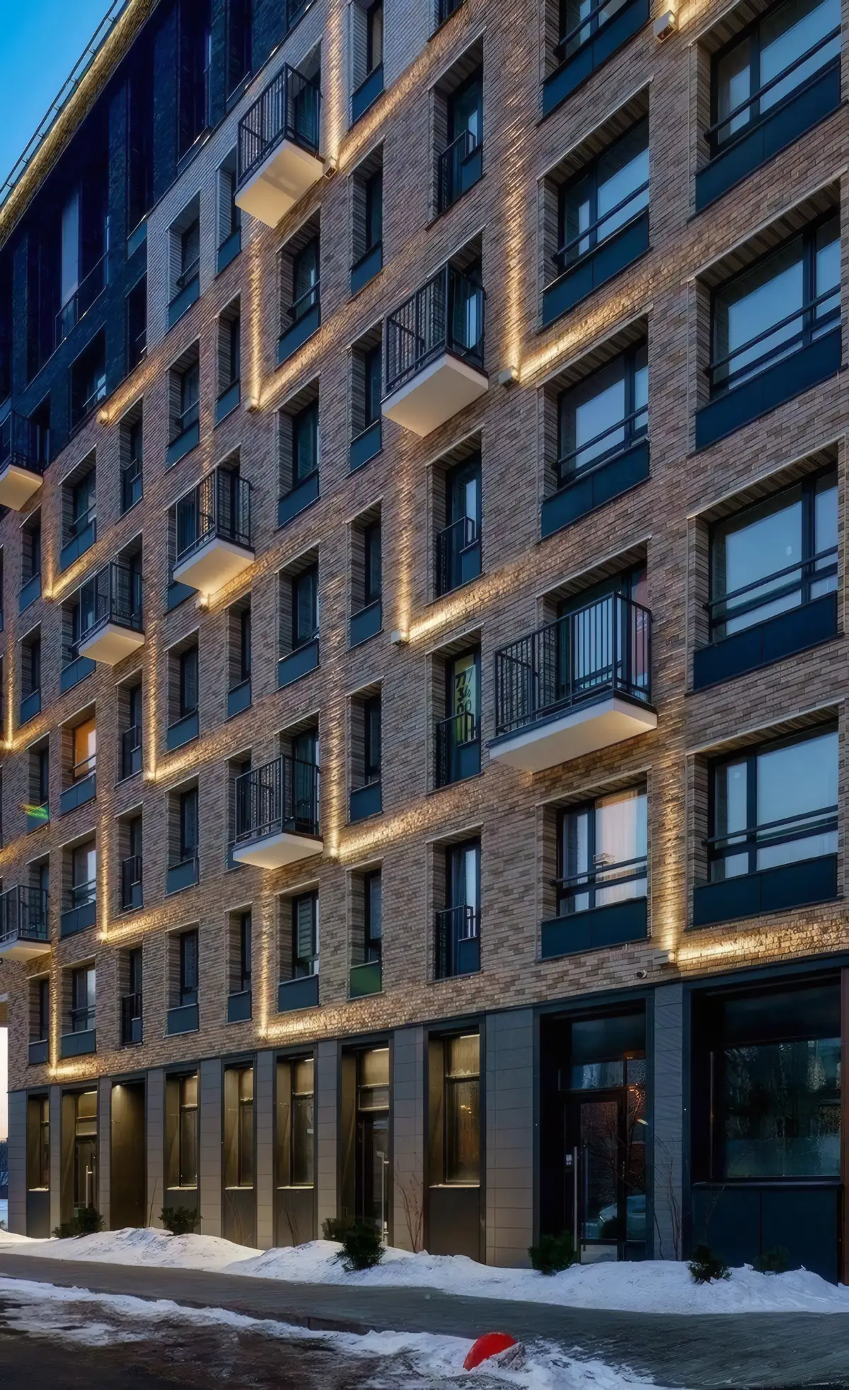 Apartment facade with warm wall-washer light framing each window